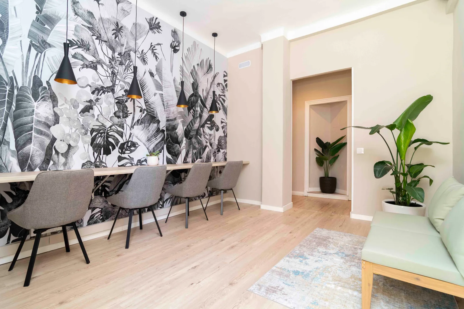 Sala de coworking del centro de negocios Madrid Abascal con mesa larga, sillas grises y mural decorativo
